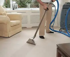 Carpet cleaning professional removing dirt and stains with a hot-water extraction tool in a home, Louisville, KY.