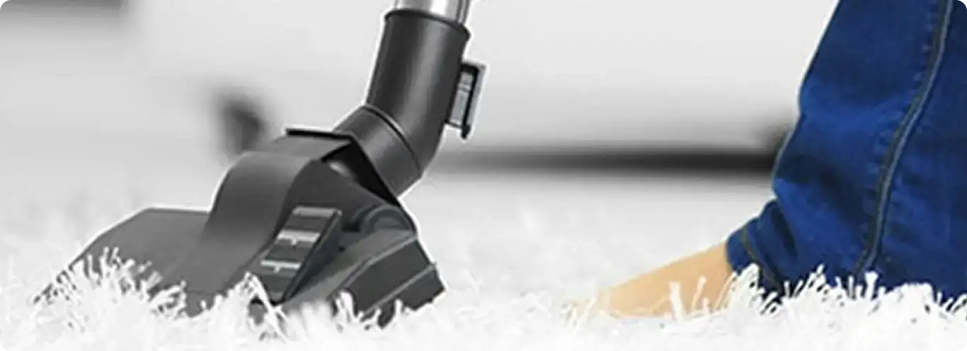 Close-up of a professional vacuuming a white carpet in Clarksville.